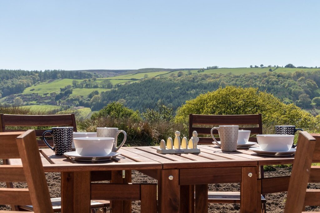 Coffee and tea cups on a wooden table overlooking the farm