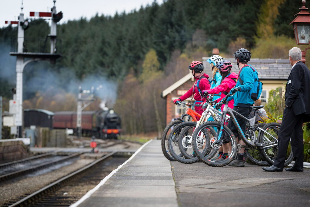 cyclists at a train station watching the train pull in