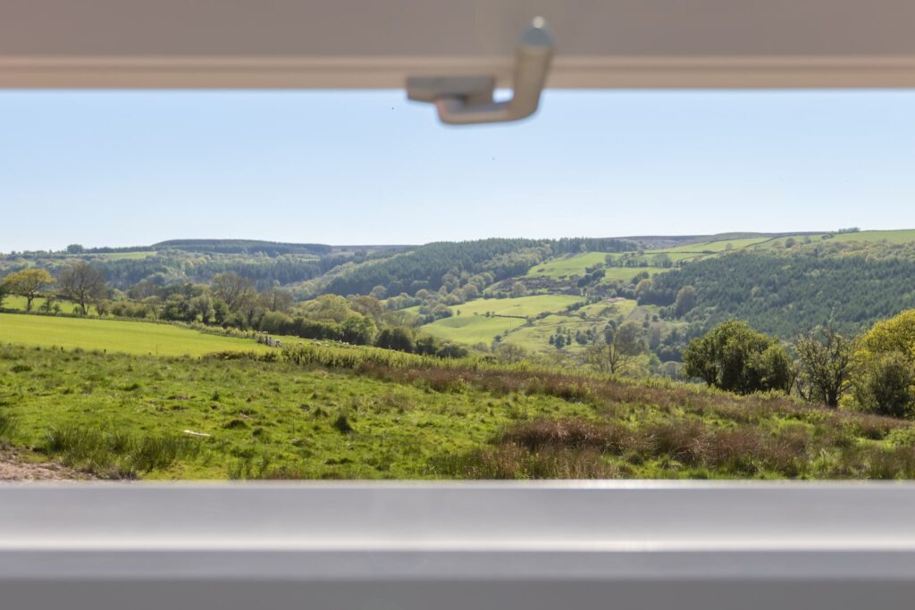 view of the green farm pastures from a house window